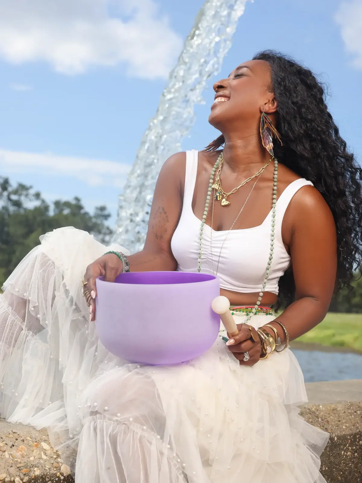 Tieara Dokes seated outdoors with a lavender singing bowl